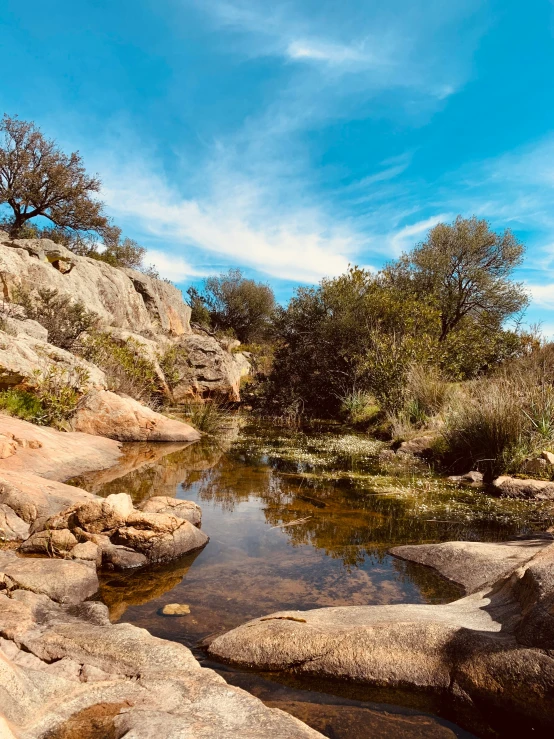 small creek near rocky terrain on sunny day