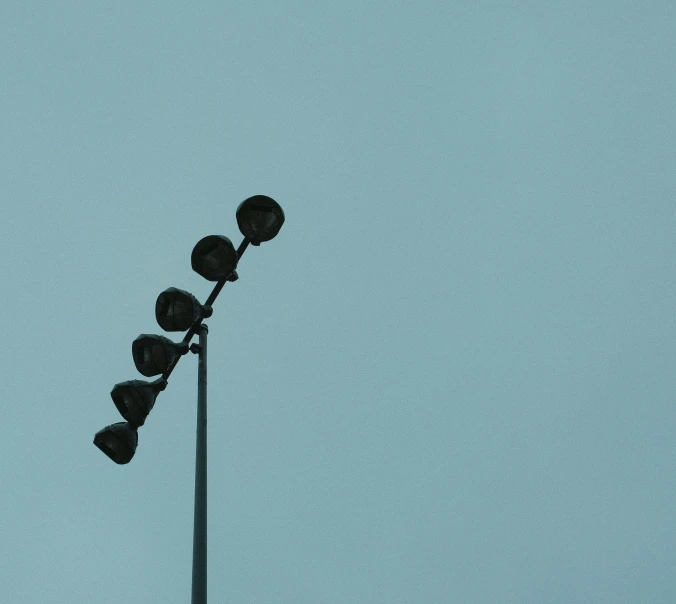 a row of lights on top of a metal pole