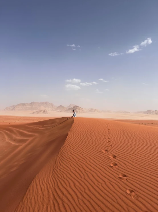 the desert with lots of large dunes and footprints