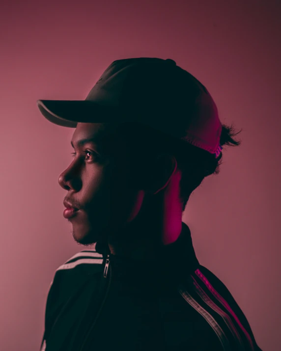 a guy wearing a hat on a pink background