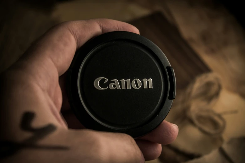 a person holds the top half of an lens cap for their camera