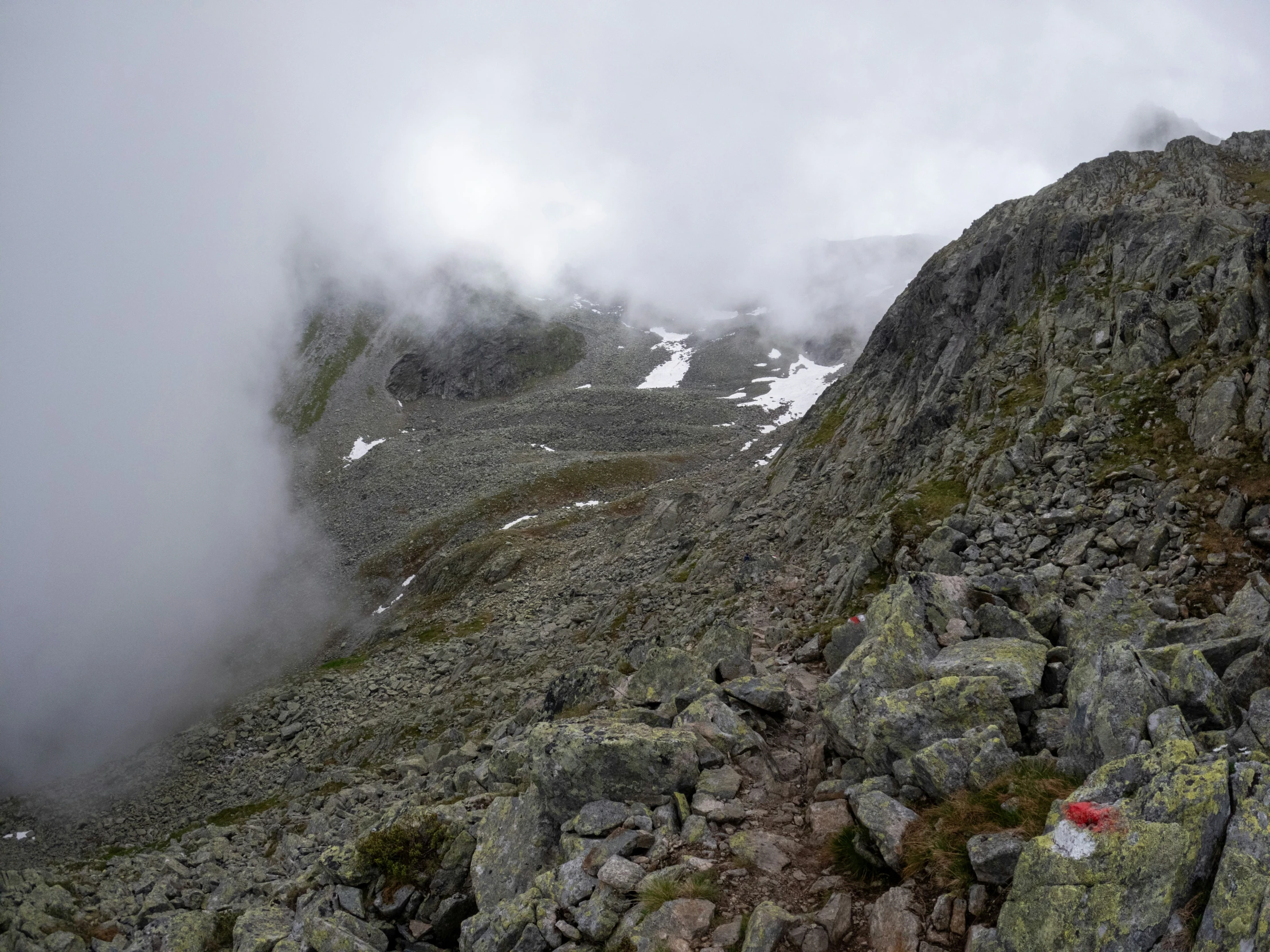 a mountain climbers climbing up the side of a steep mountain