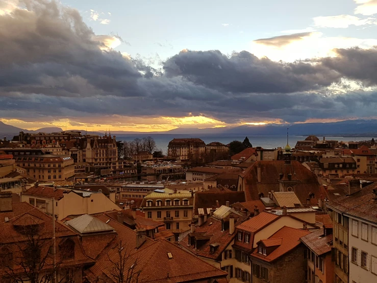 a city has clouds above buildings and the sun is shining