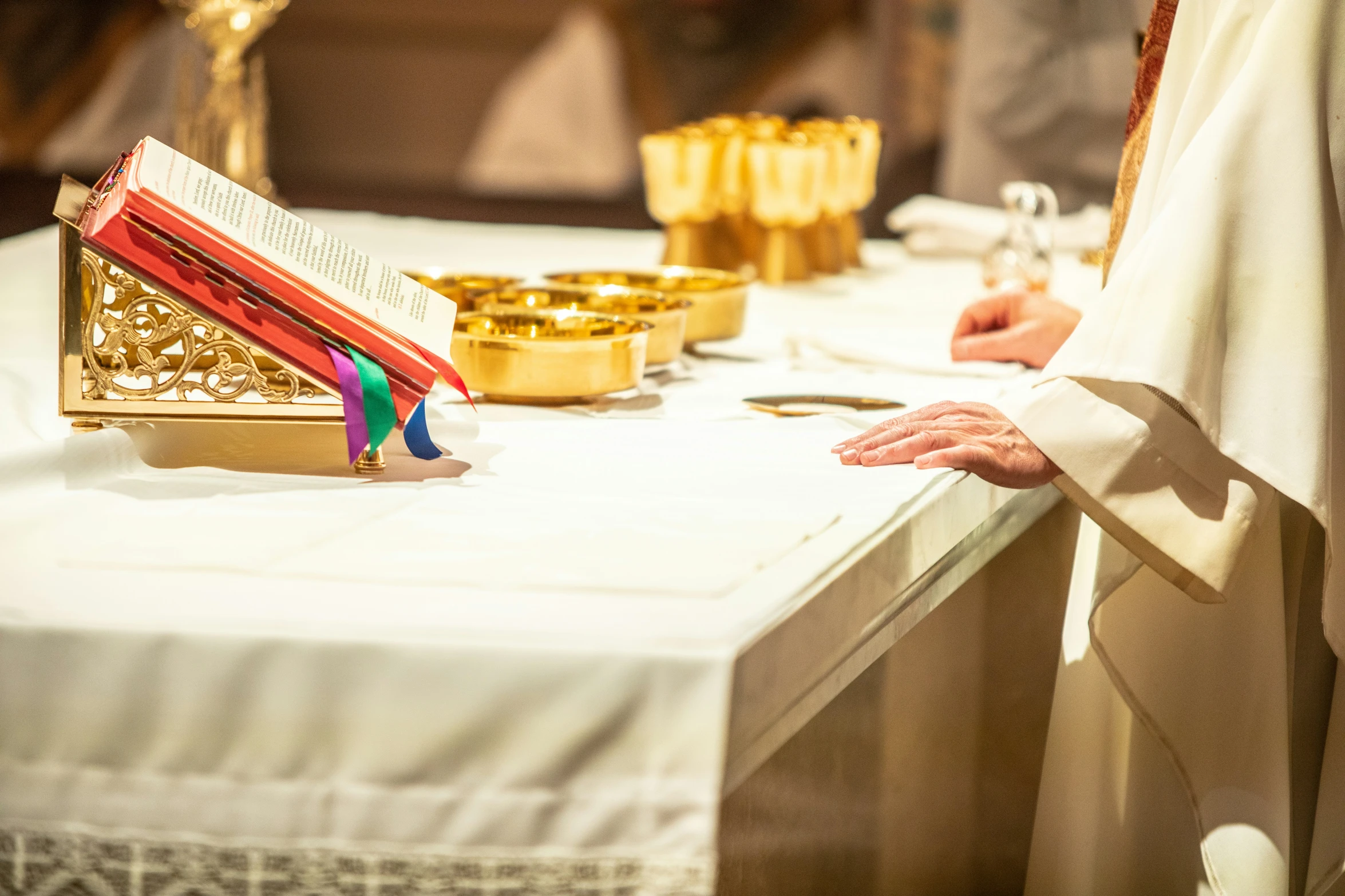 the priest stands before a table with an open book