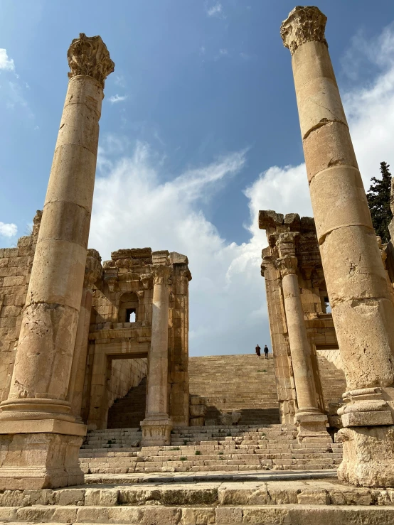 an old greek temple with two large pillars and one sitting on steps