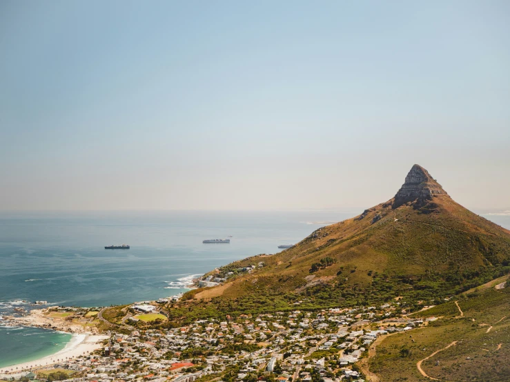 a view from the top of a hill shows the city and sea