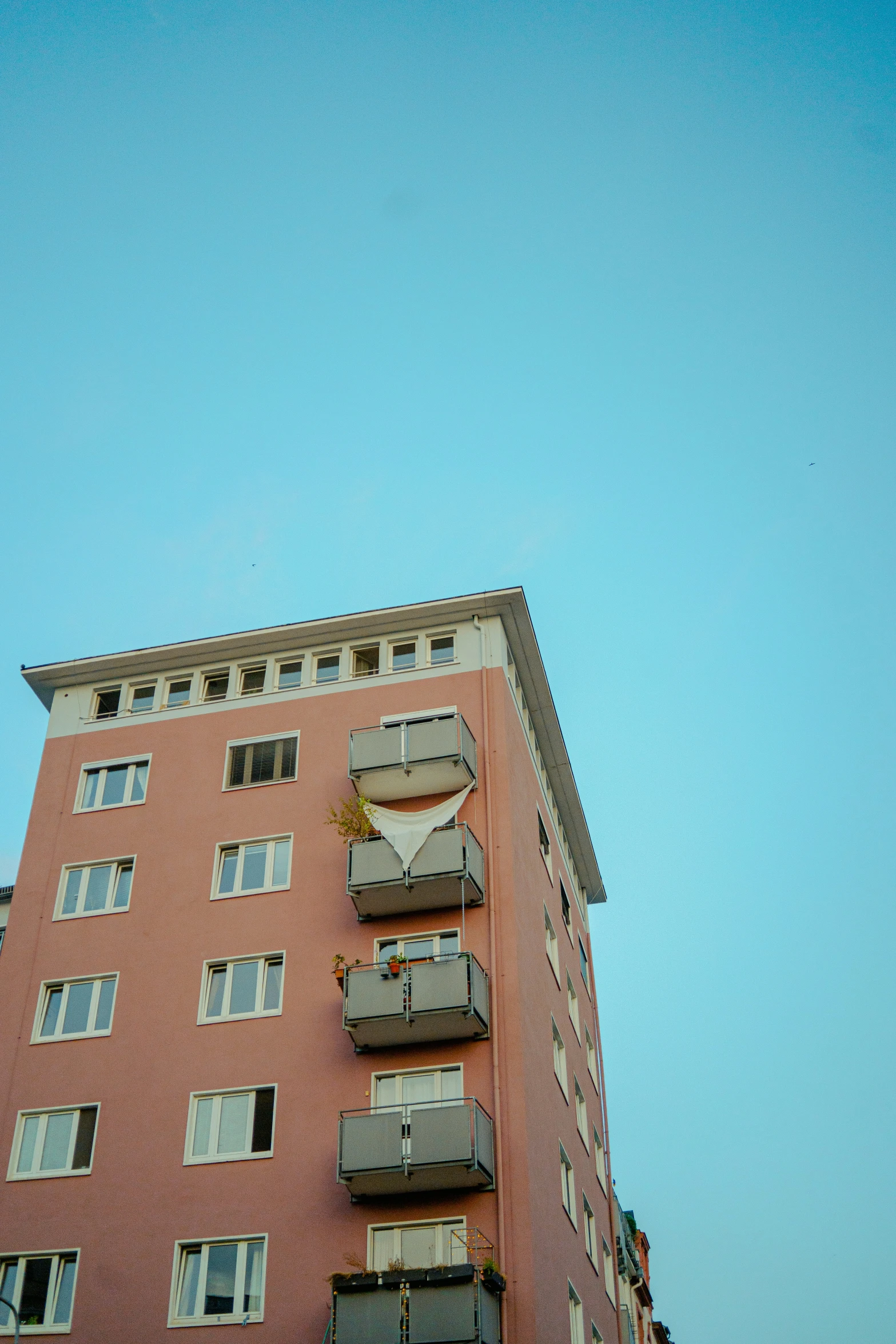 a tall red building with balconies on the top