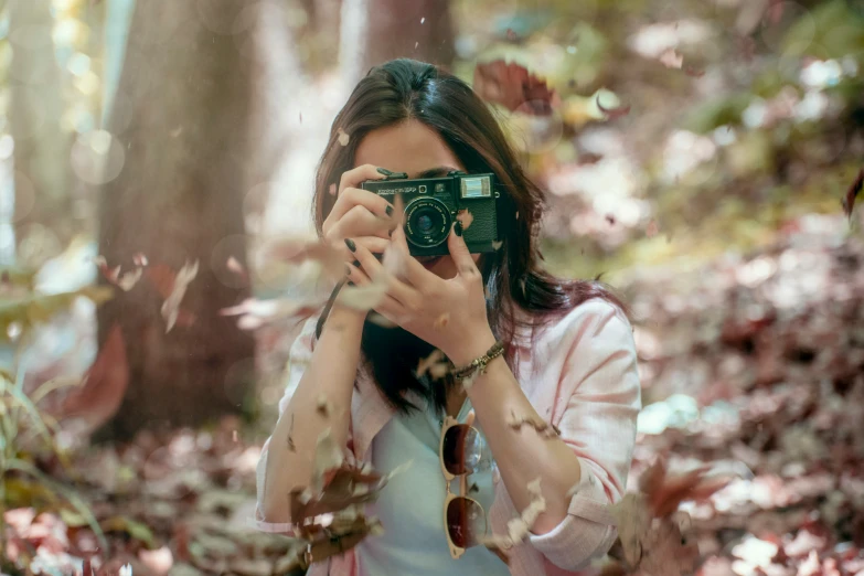 a person holding a camera taking pictures of the woods