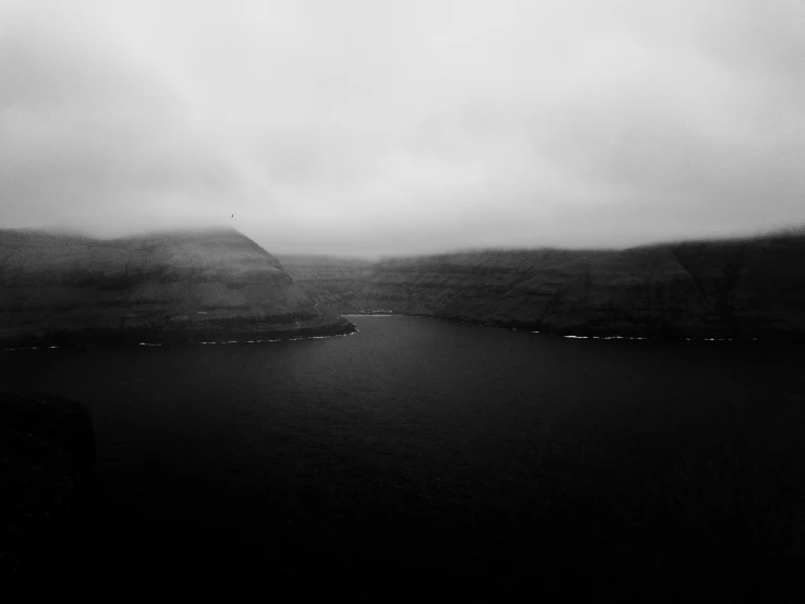 a picture taken from a plane of a lake with fog in the sky