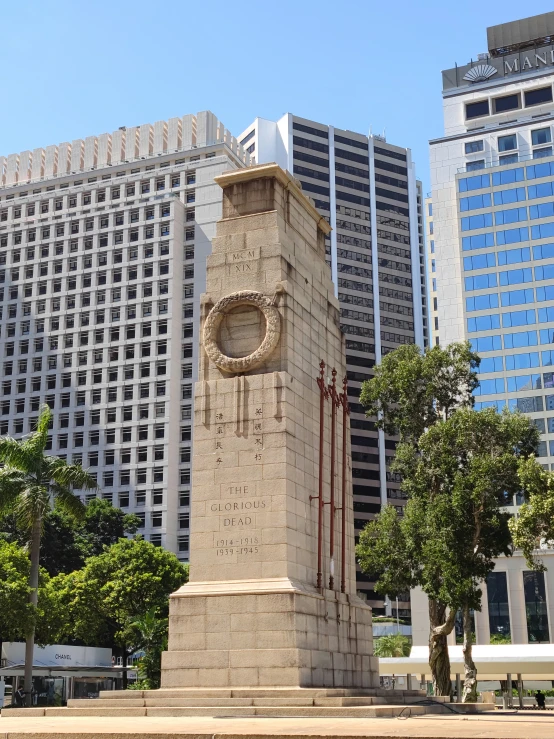 a statue sitting in front of a cityscape