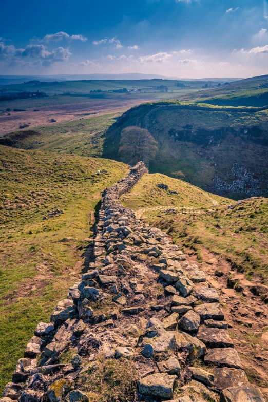 an old stone road in a vast valley