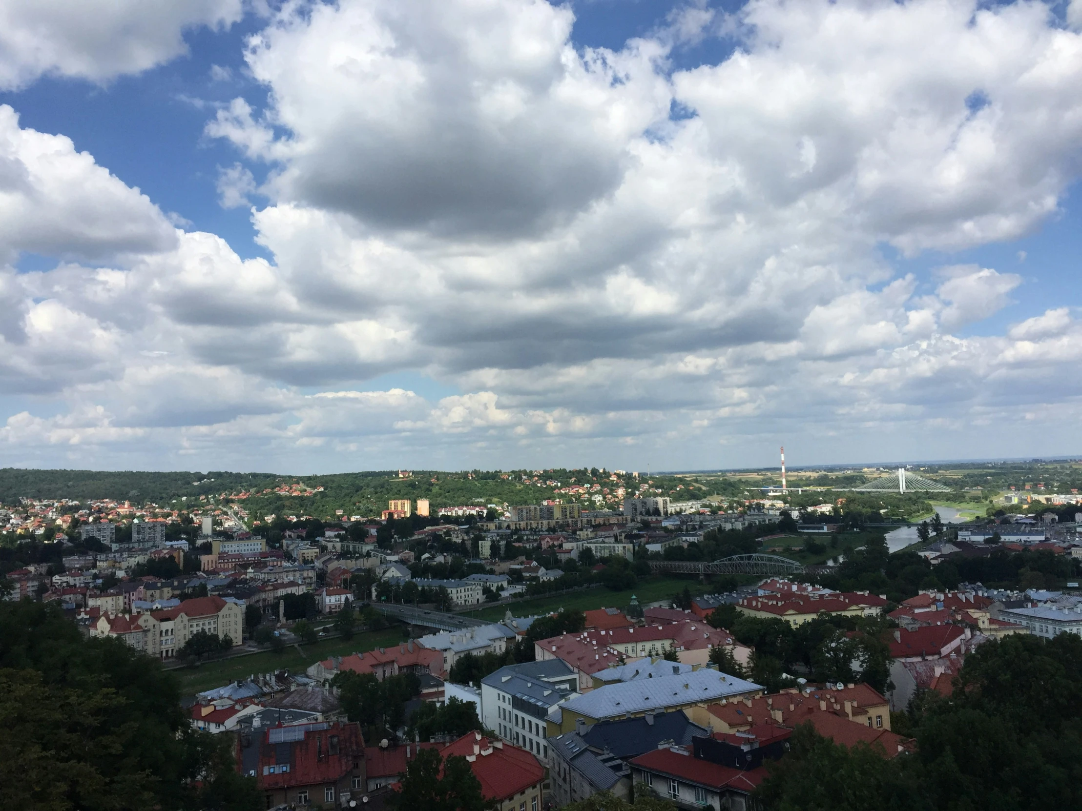 the clouds are partly covering the city as seen from the hill