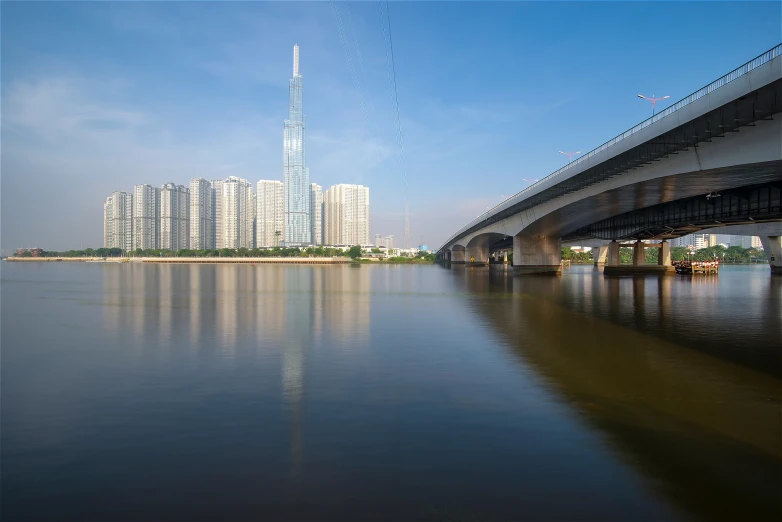 a bridge crosses over the water in front of some tall buildings