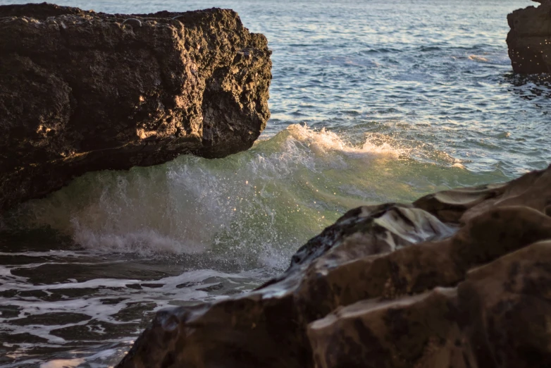 a rock cliff with waves coming out of it