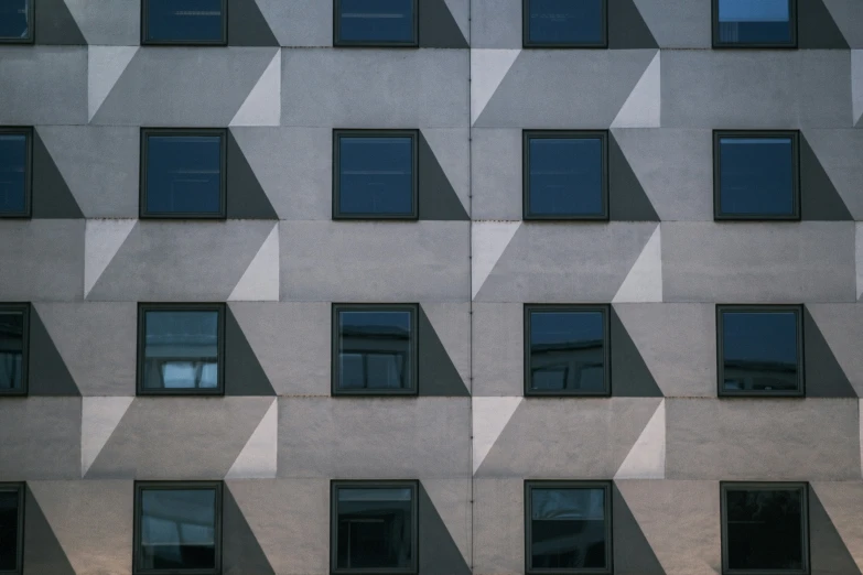 an abstract, stone wall is reflecting many windows