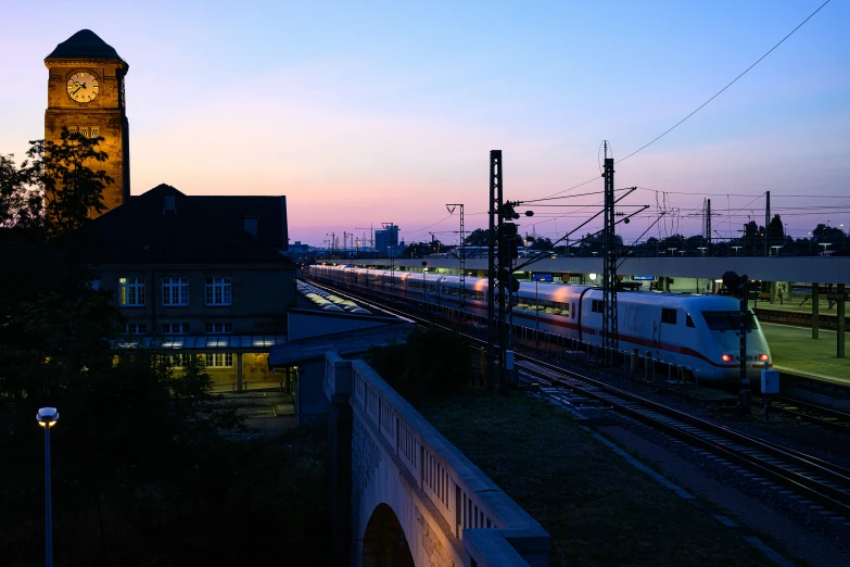 there is a train that is going down the tracks at twilight