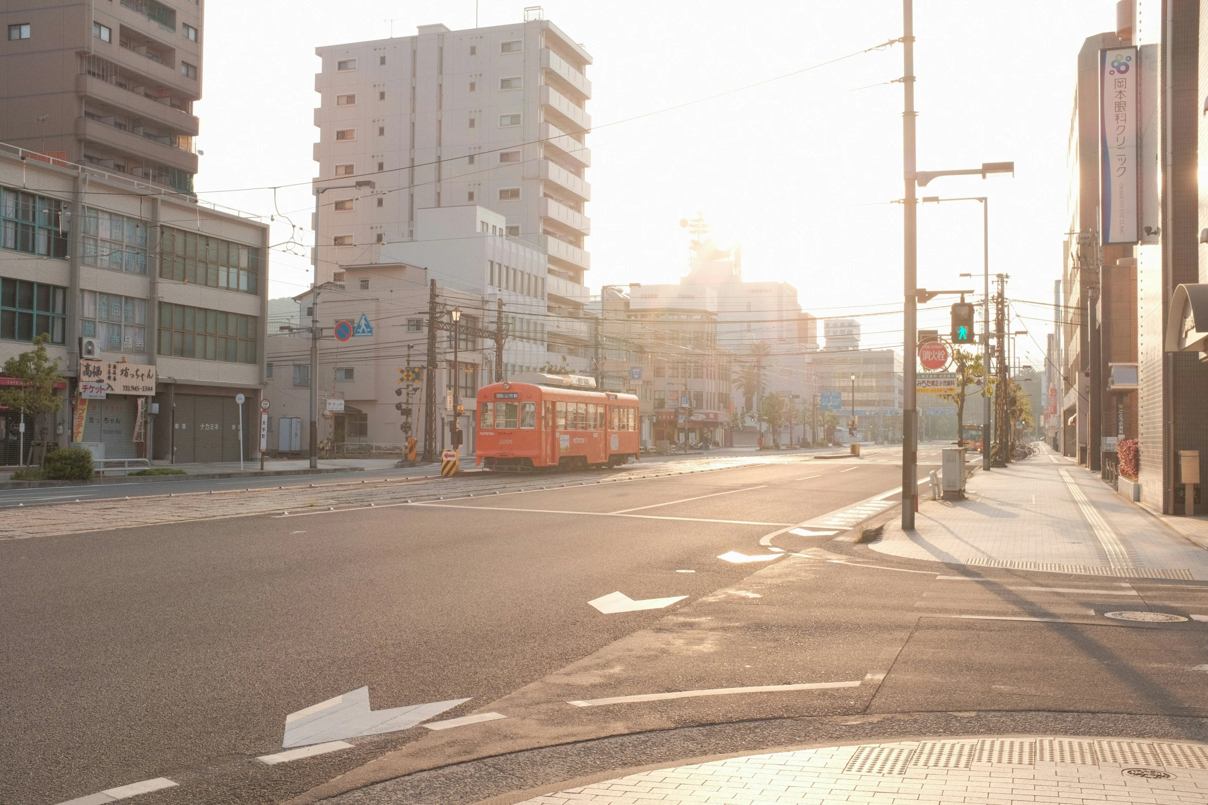 a city street with buildings and buses on both sides