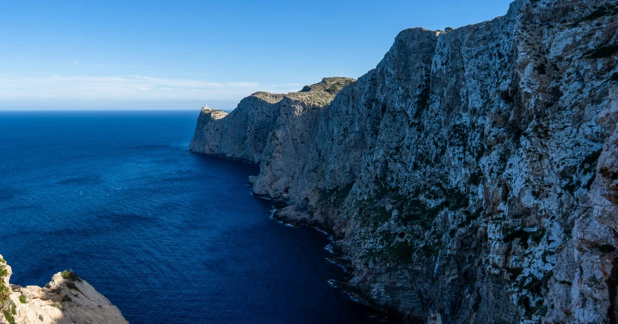 a person on the top of a cliff overlooking the ocean