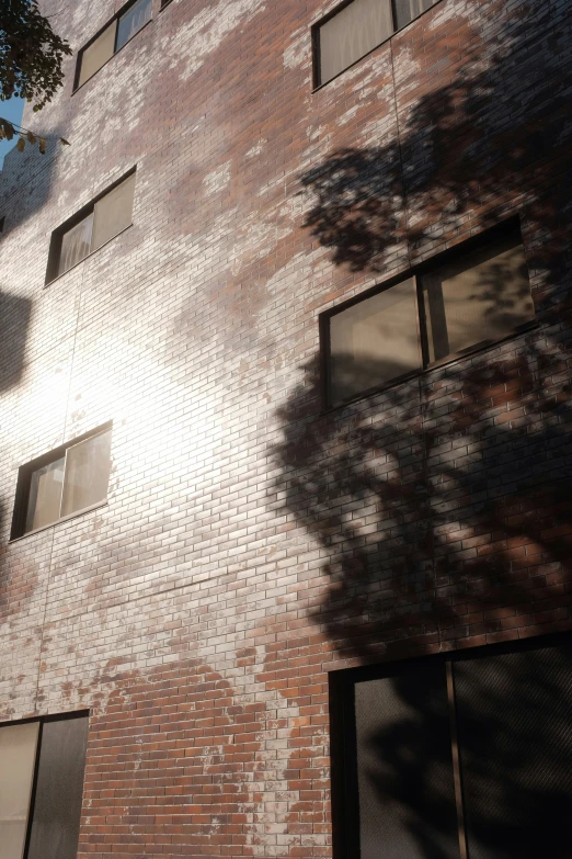 the back of an apartment building's side has three windows