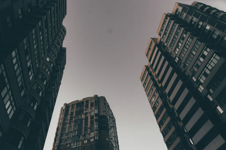 the tops of several buildings stand against a cloudy sky