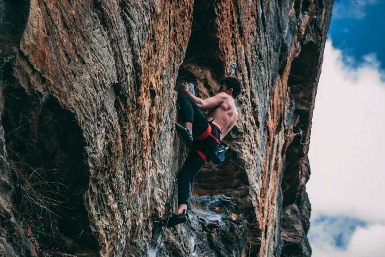 a man that is climbing up the side of a mountain