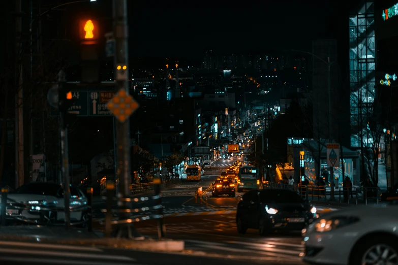 a busy city street at night with traffic stopped in the intersection