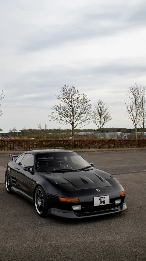 the black sports car is parked outside in a parking lot