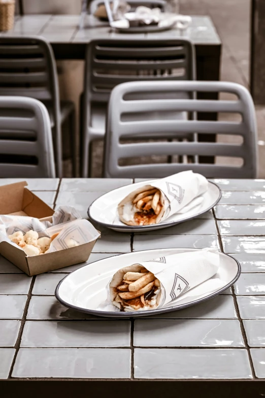 an empty lunch box and a half eaten sandwich are on the table