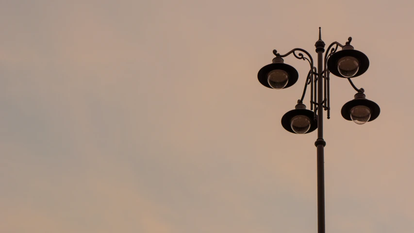 three lamps are attached to a light pole