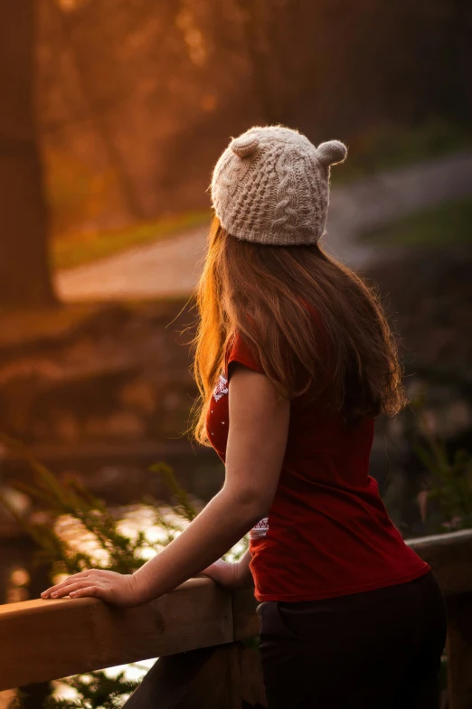 a woman in red and white sweater leaning on rail