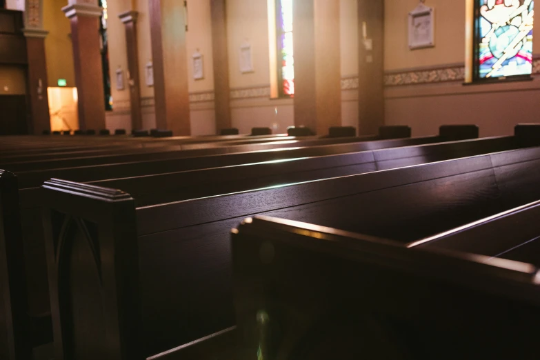 a pew in a church in front of a stained glass window