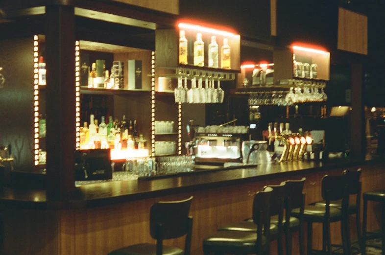 empty wine glasses and bottles on the bar counter