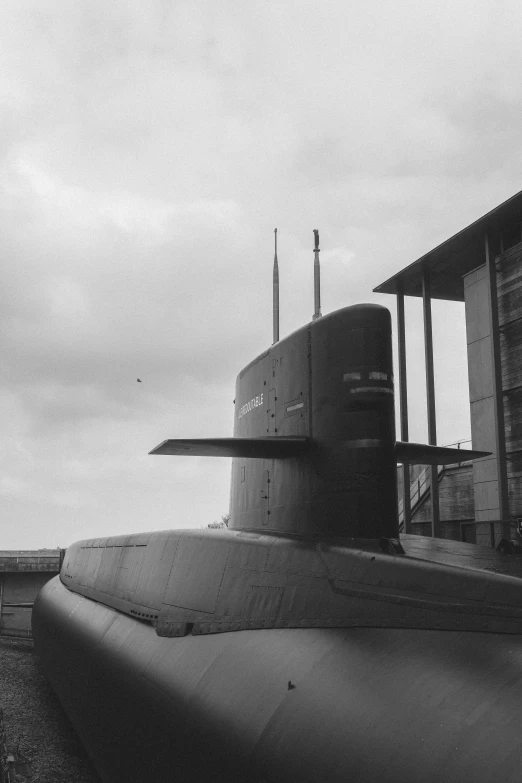 a black and white image of a submarine on train tracks