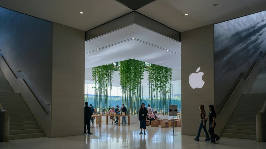 people walking through a lobby in an apple store
