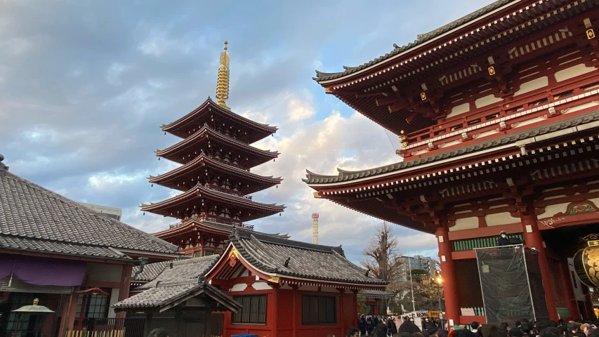 a red and black pagoda and some people under it