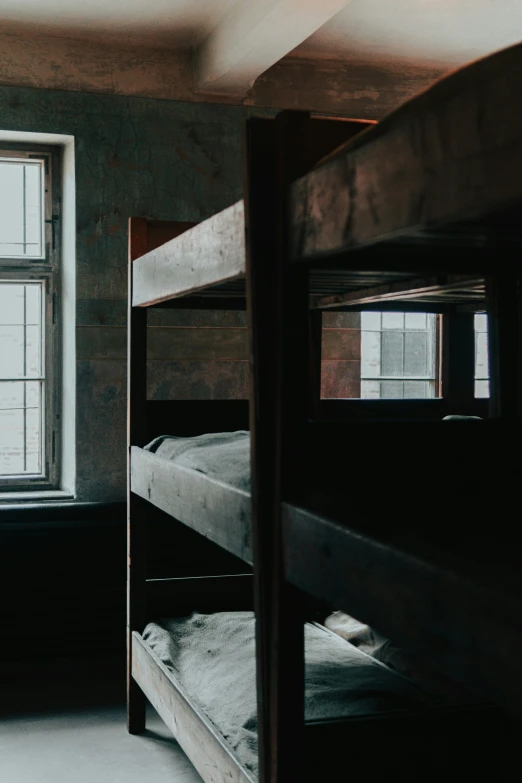 a room with a ladder, window and bunk beds