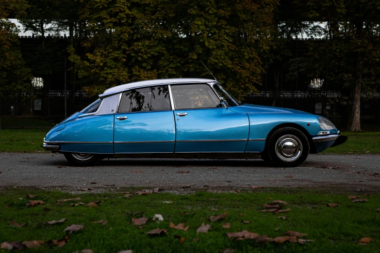 a very cute blue car parked near some green grass