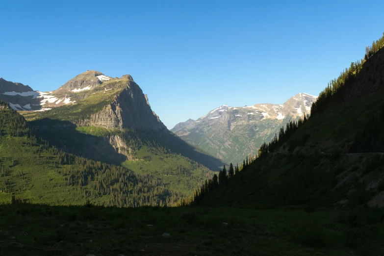 a mountainous area with large rocks, trees and mountains