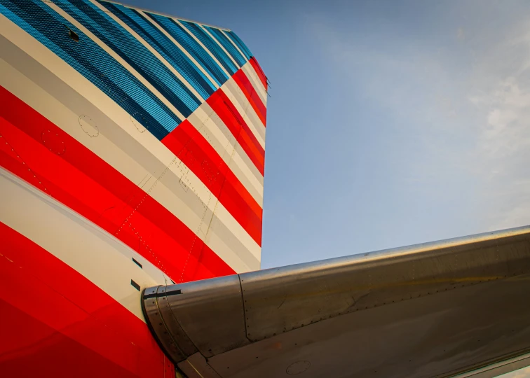 looking up at the side of a plane tail with a flag pattern