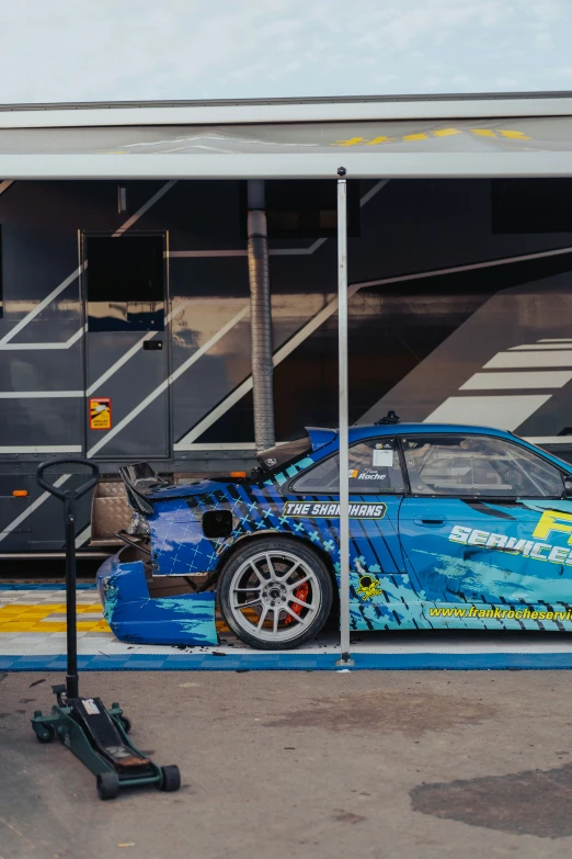 a blue sports car parked in front of a building