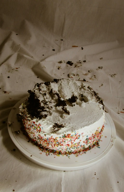 a partially eaten cake with sprinkles and frosting