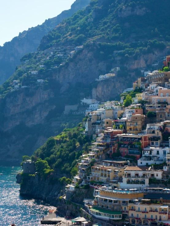 a scenic view of some houses on the cliffs above a body of water