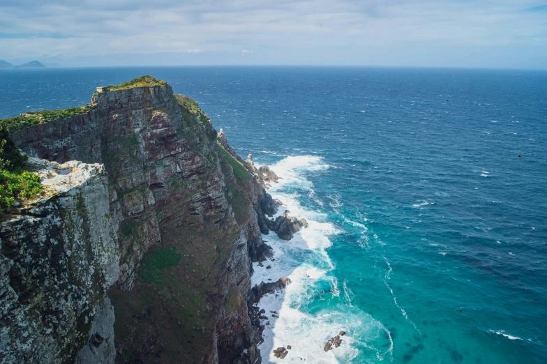 a view of the edge of a cliff in front of the ocean