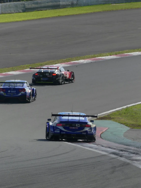 three racing cars in an intense race, during a track