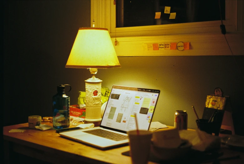 the laptop has been placed on a desk near a lamp