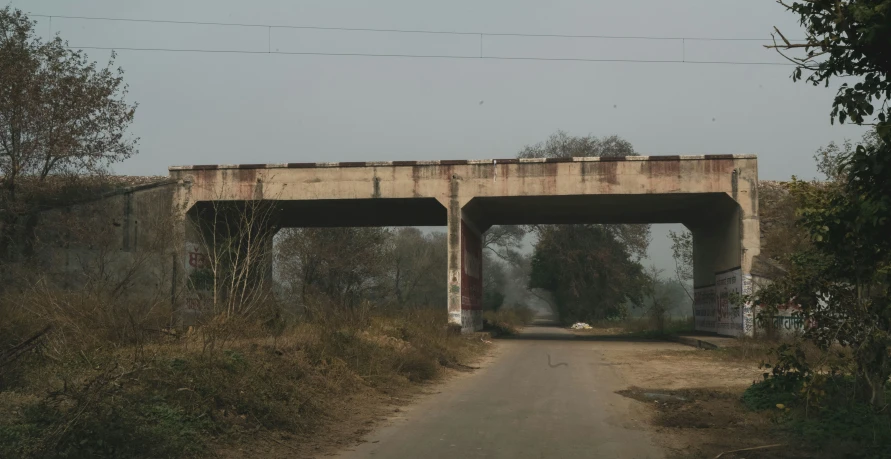 a bridge above a dirty road and dirt road