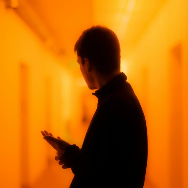 a man looking at his cell phone in the dark