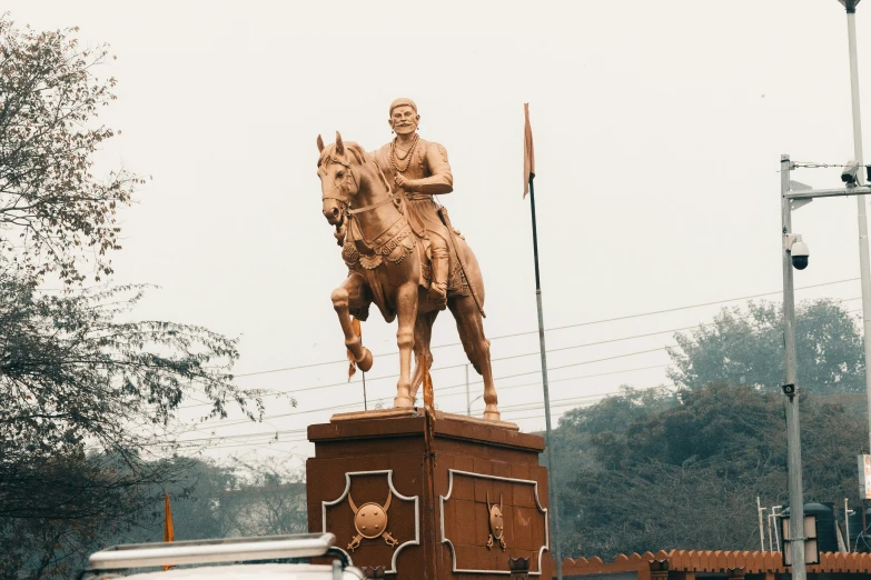 a statue of a man riding a horse near other buildings