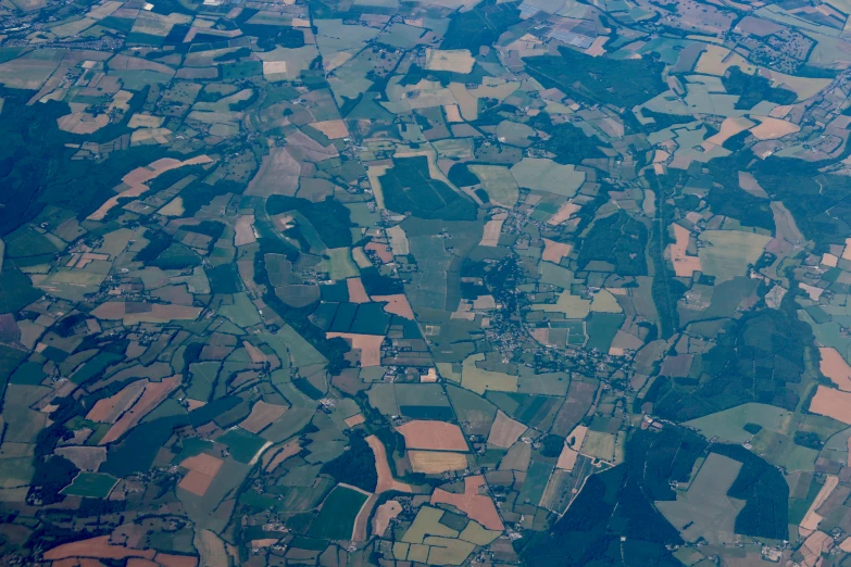 a view of some green fields from an airplane