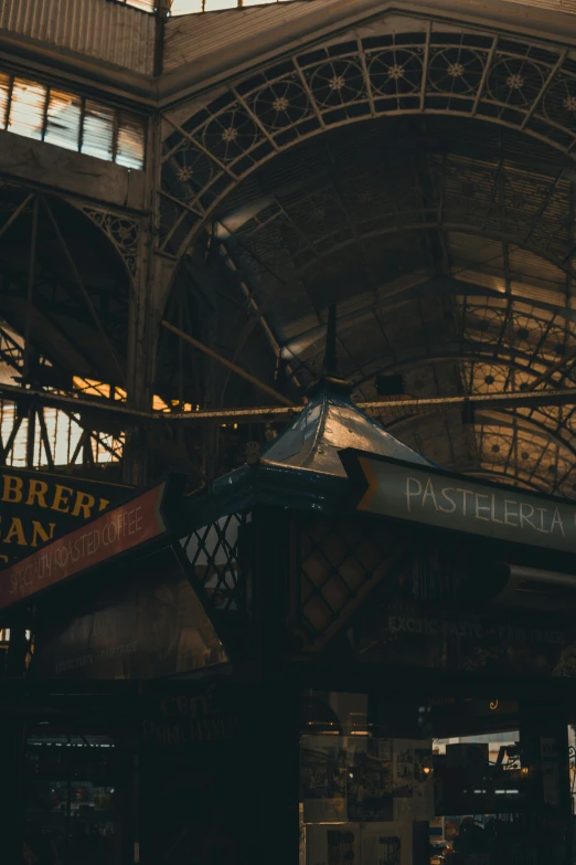 several directional signs suspended above an old train station